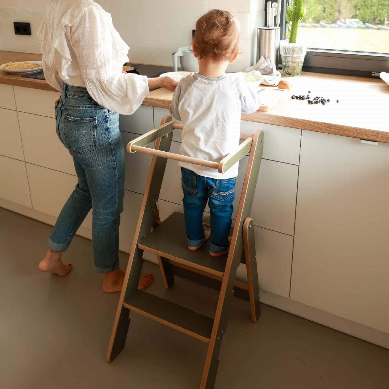 Faltbarer Küchenhefer, versch. Farben, extradünn in Aktion mit Kind und Elternteil in moderner Küche.