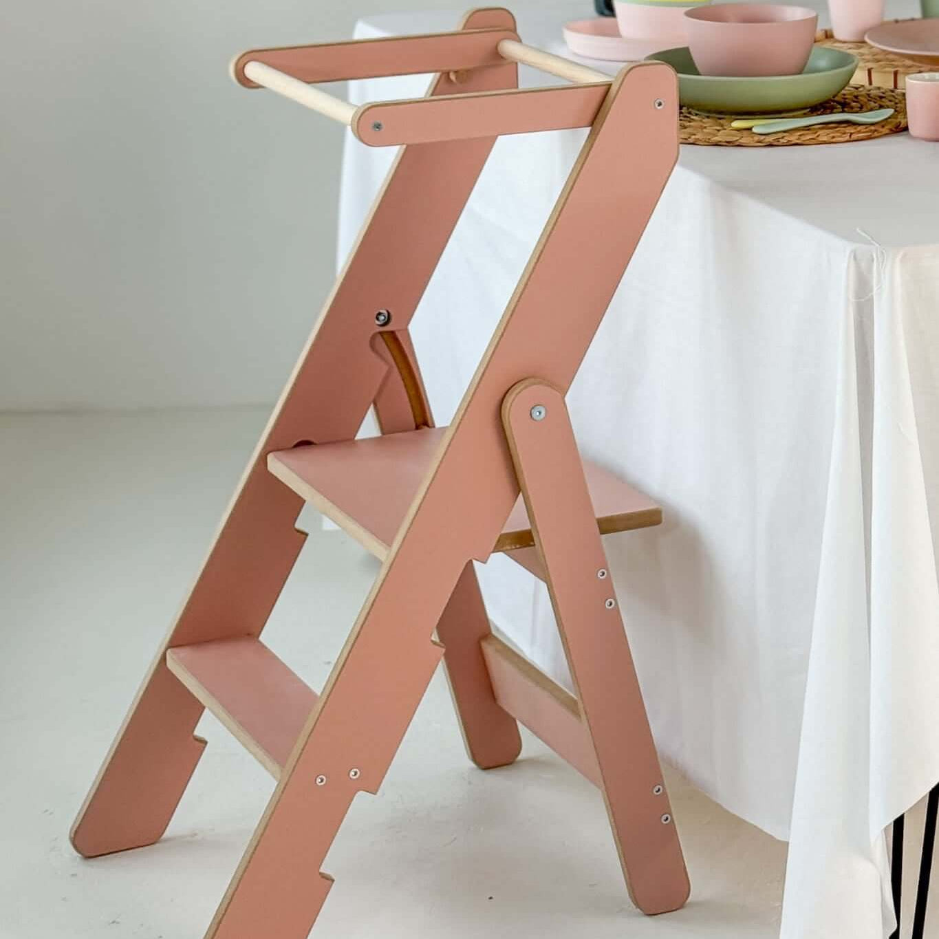 Faltbarer Küchenhelfer, versch. Farben, extradünn - pinker Lernturm neben einem Tisch mit Geschirr.
