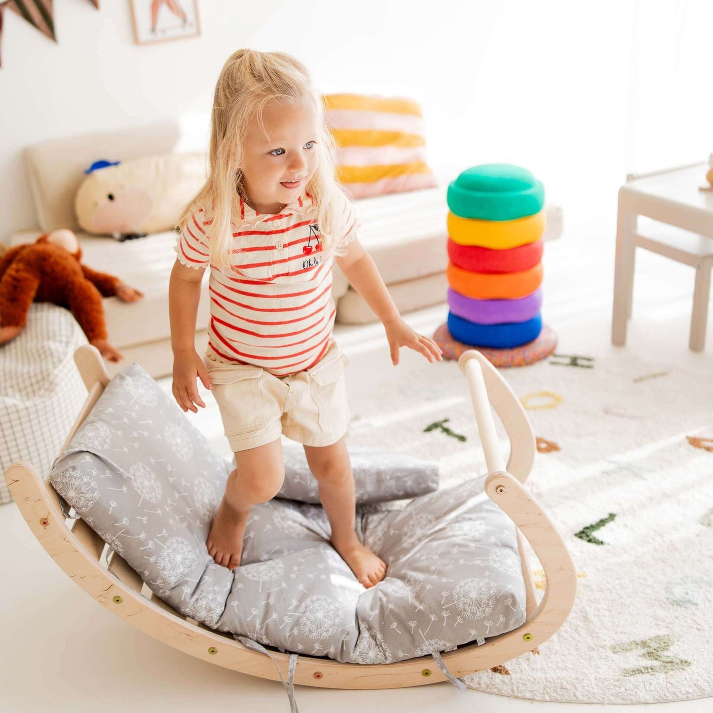 Kinder spielt mit Kletterbogen Äffchen, Holzschaukelspielzeug fördert Bewegungsfähigkeiten, Spielzeug im kinderfreundlichen Raum.