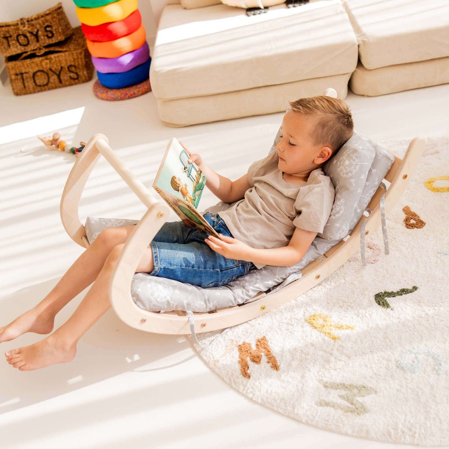 Junge entspannt auf Kletterbogen Äffchen mit Buch, zeigt vielseitiges Spielzeug für Bewegung und Kreativität.