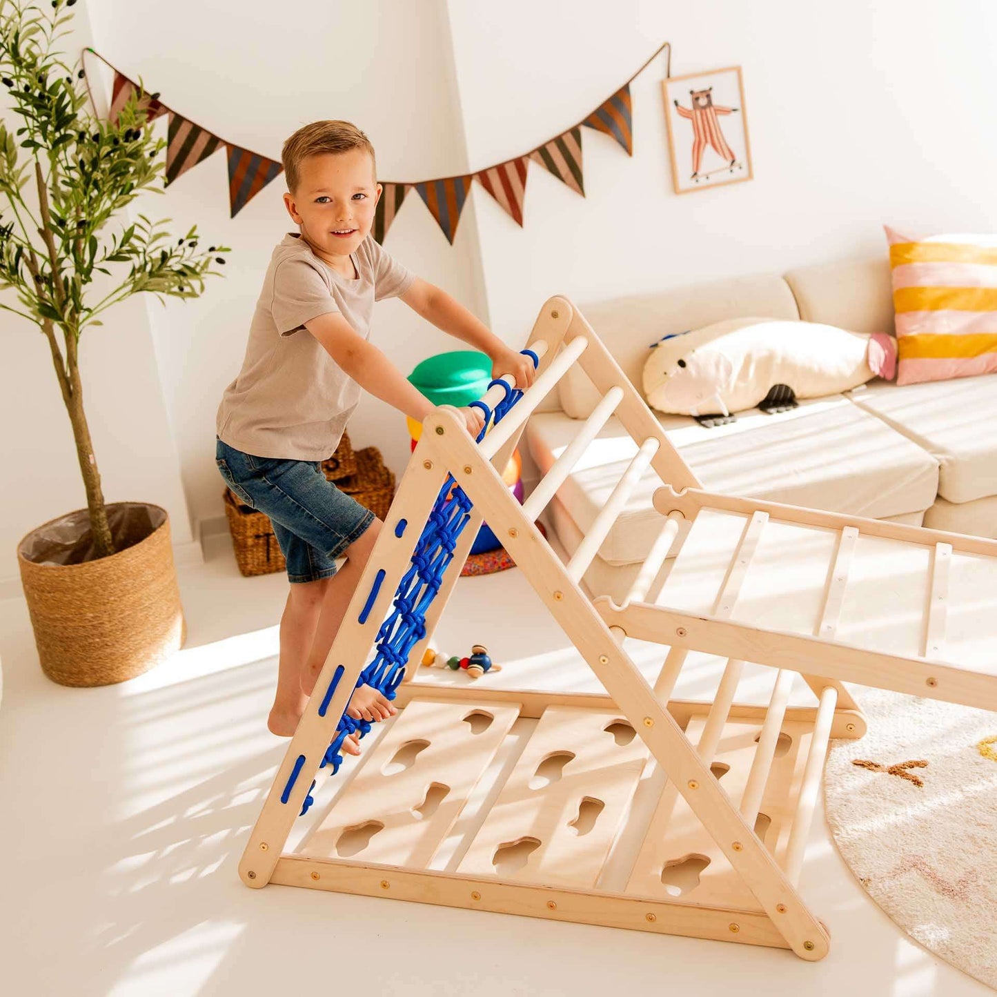Kind klettert auf dem Kletterset Löwe aus Holz mit Kletterdreieck und Hühnerleiter für spielerische Bewegungsförderung.