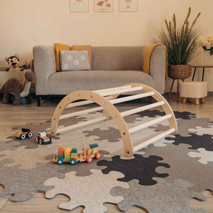 Kletterset Luna mit Kletterdreieck, Rutsche und Spielzeug auf einem bunten Puzzle-Teppich in einem gemütlichen Kinderzimmer.