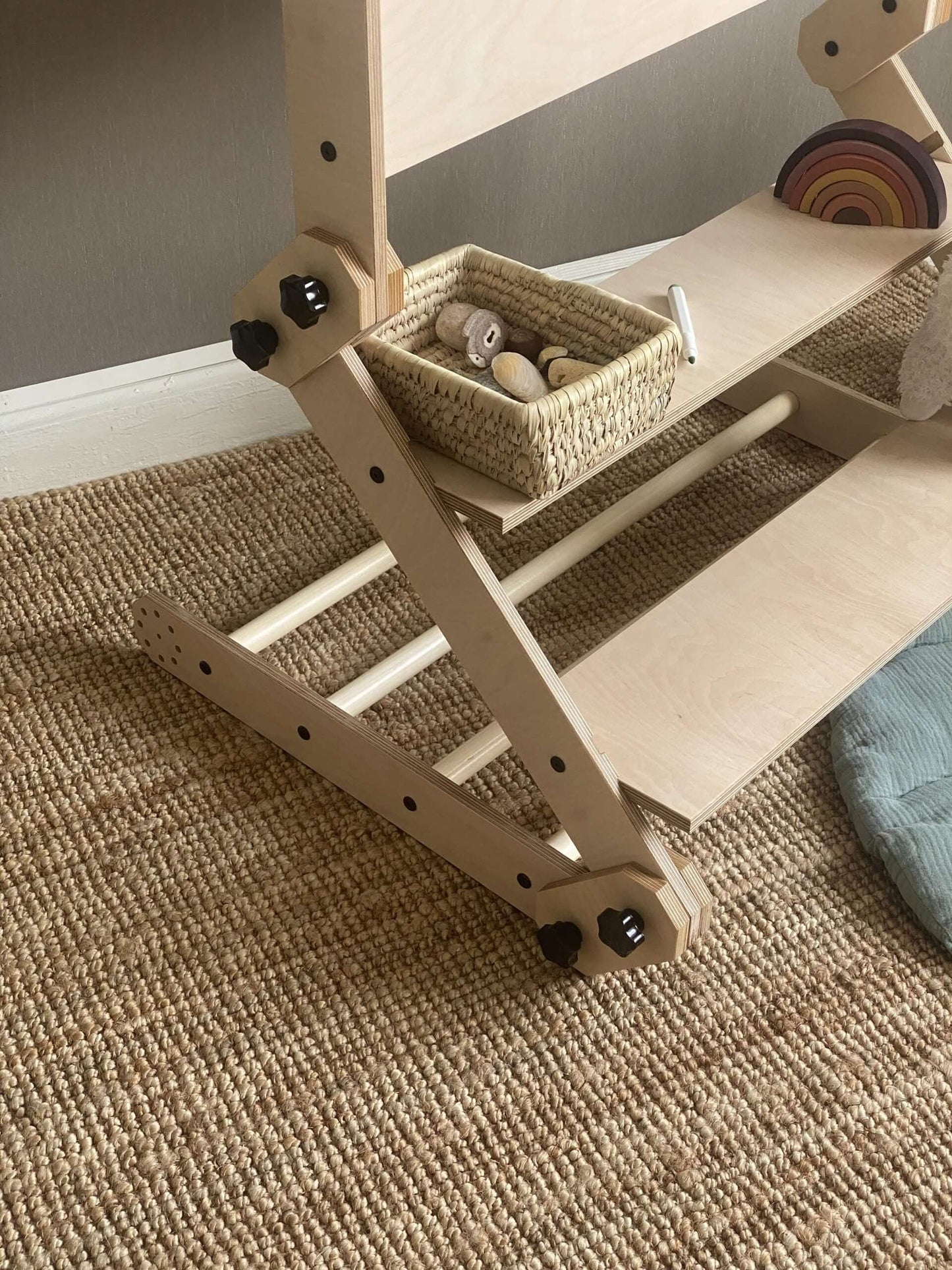 Kletterset / Klettertisch NABU with storage basket and wooden toys on a textured carpet surface.