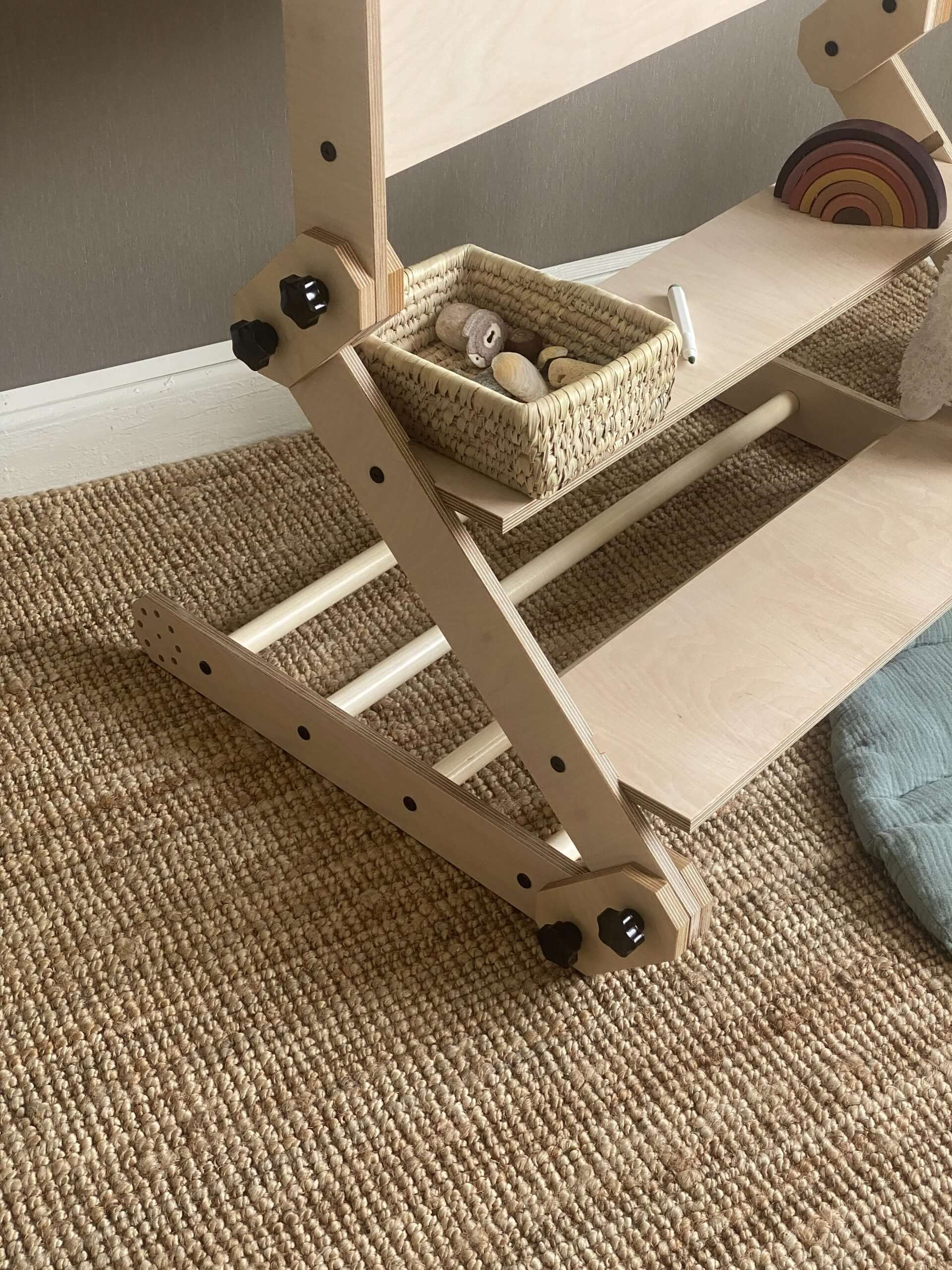 Kletterset / Klettertisch NABU with storage basket and wooden toys on a textured carpet surface.