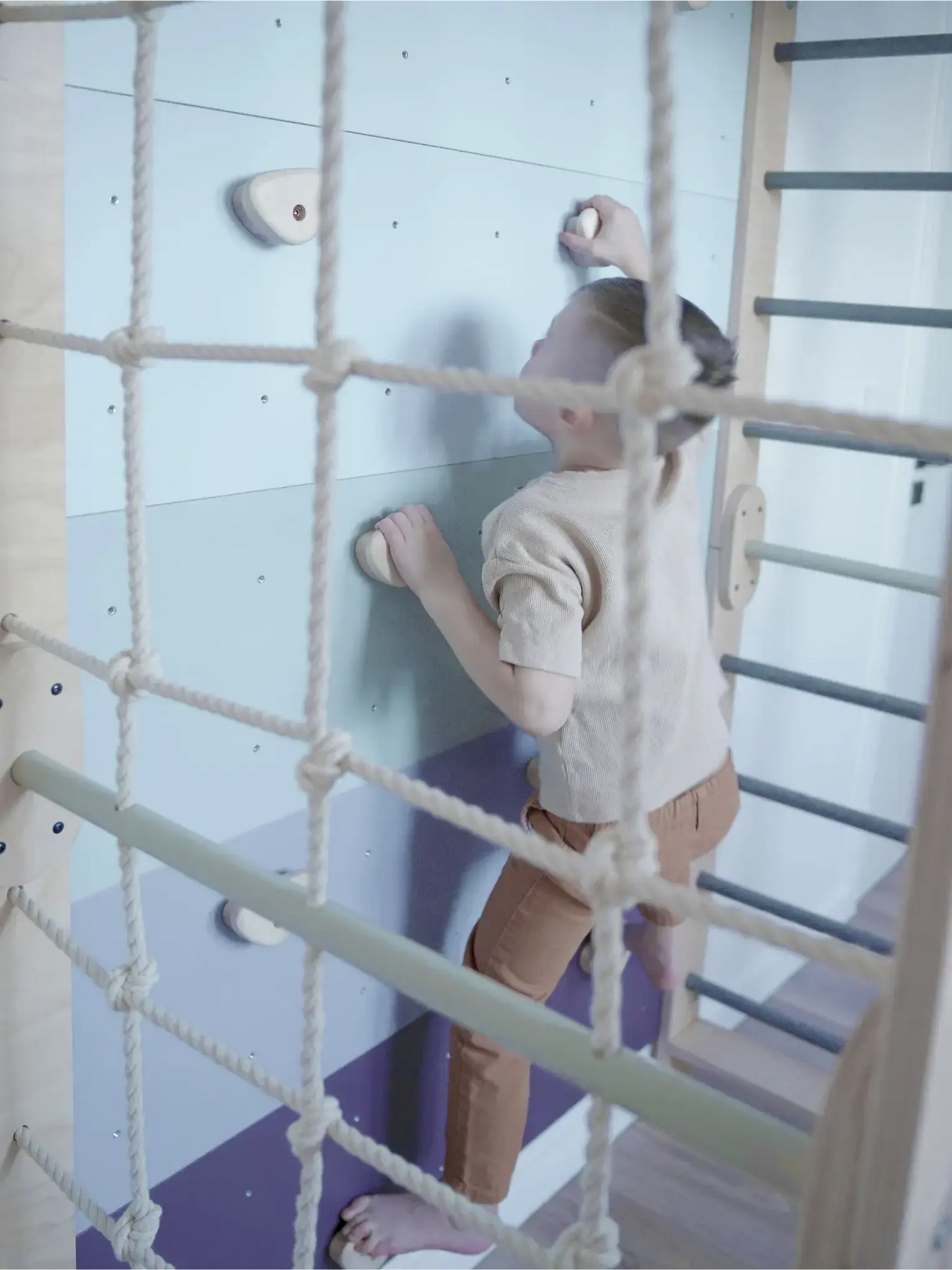 Kletterwand Klimby "Entdecker" – Kind erklimmt bunte Kletterwand im Indoor Spielplatz für Kinder.